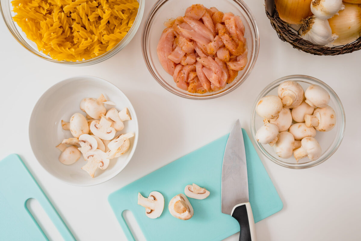 8 Ways to Avoid Food Poisoning 3 Fresh raw pasta, marinated chicken fillet, mushrooms, onion and garlic. Ingredients close up on white background, view from above