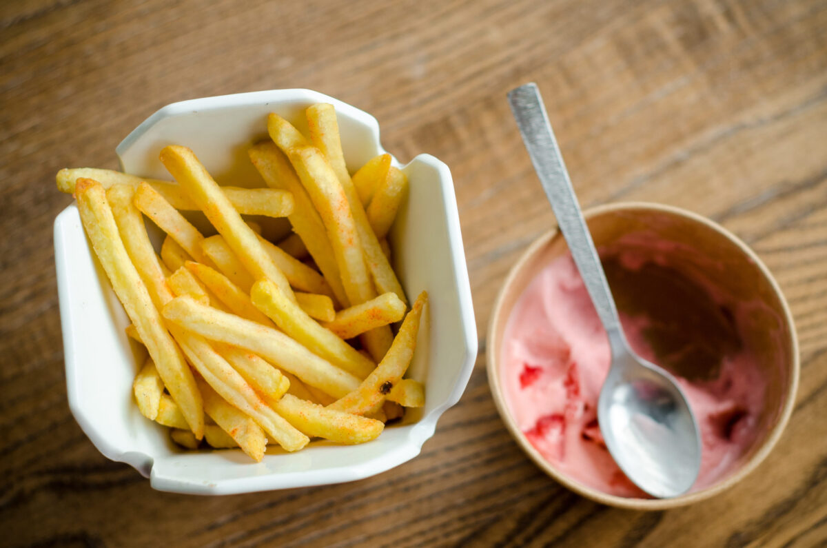 7 Unexpectedly Delicious Food Pairings You Need to Try Right Now 3 Fries and ice cream with a spoon are served at the restaurant in a in white porcelain and paper boxes on a wooden table