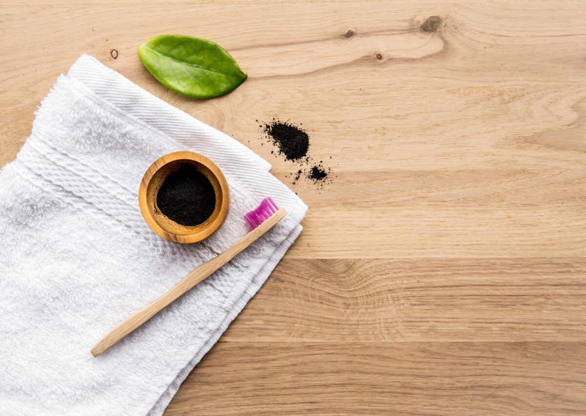 These 6 Celebrity-Approved Foods Are Actually Terrible for You 1 Raw activated charcoal powder in wooden cup and natural bamboo toothbrush next to it, green leaf and bath towel. Charcoal toothpaste concept. Lot of copy space.