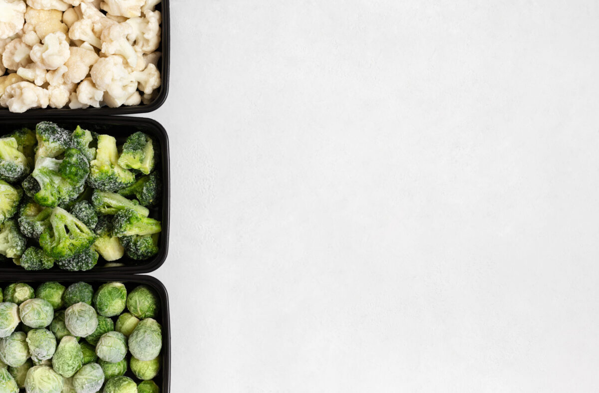 What You Should Be Eating to Prevent the 5 Most Common Aging Diseases 4 Border of frozen vegetables in containers on a white background. Cabbage mix. Brussels sprouts, broccoli, cauliflower. View from above. Copy space.