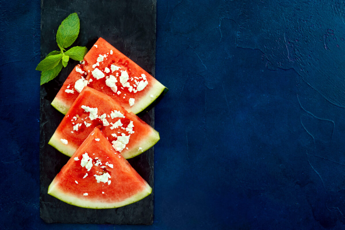 7 Unexpectedly Delicious Food Pairings You Need to Try Right Now 1 Top view of watermelon slices with feta cheese on blue background. Copy space