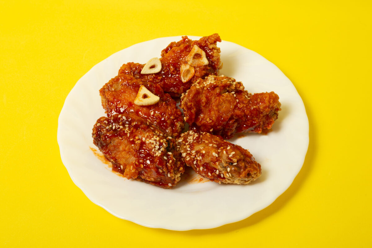 The Caloric Nightmare 4 Crispy sesame chicken legs with sticky sweet Asian sauce on a plate