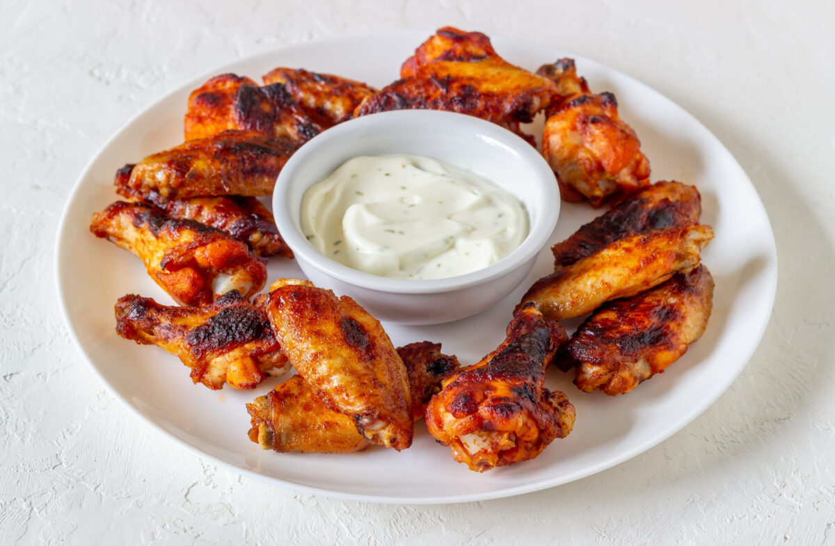 9 Foods You Should Never Order at a Chain Restaurant 1 Barbecue chicken wings on a white background. Grill. Recipe.