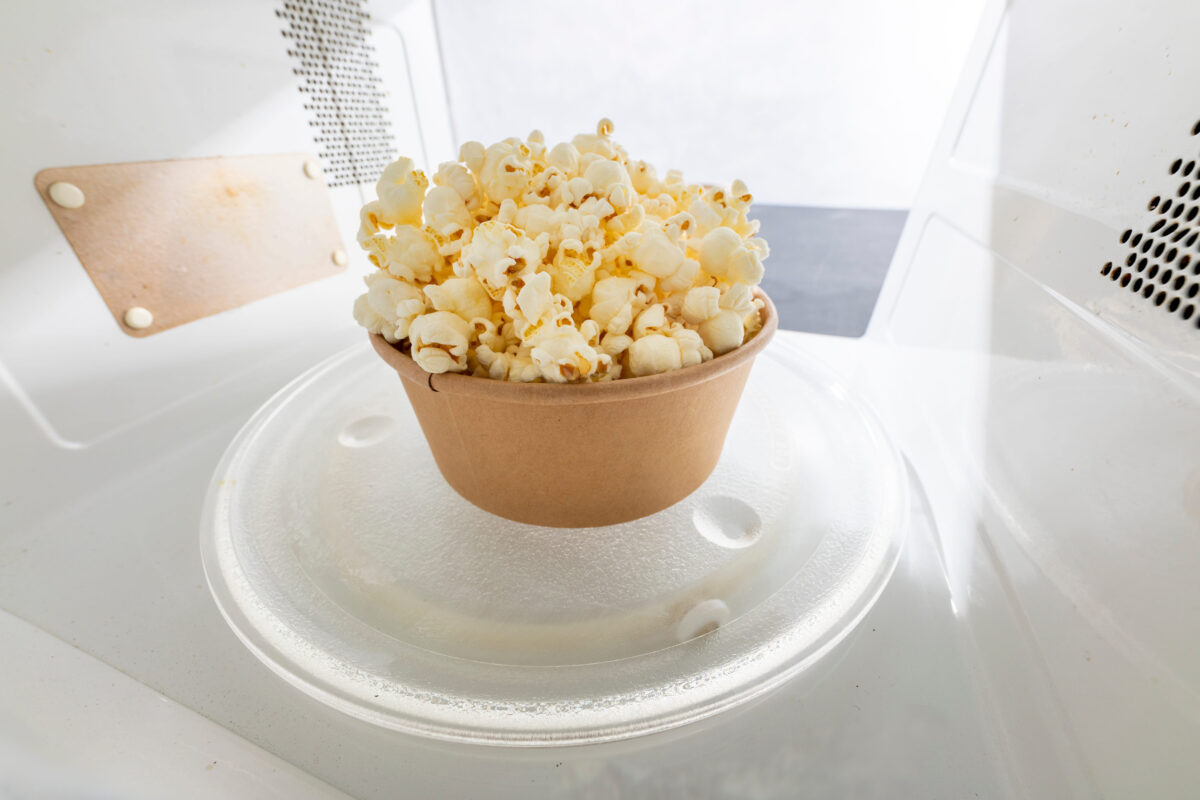 9 Foods You’re Eating That Could Be Poisoning Your Brain 4 Ready popcorn set in the microwave oven. Salty snack prepared in the kitchen appliance. Light background.