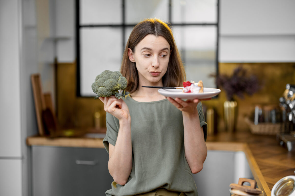 8 Impact of Long-Term Keto Diet on Your Health 3 Woman makes a choice between healthy food and sweet dessert