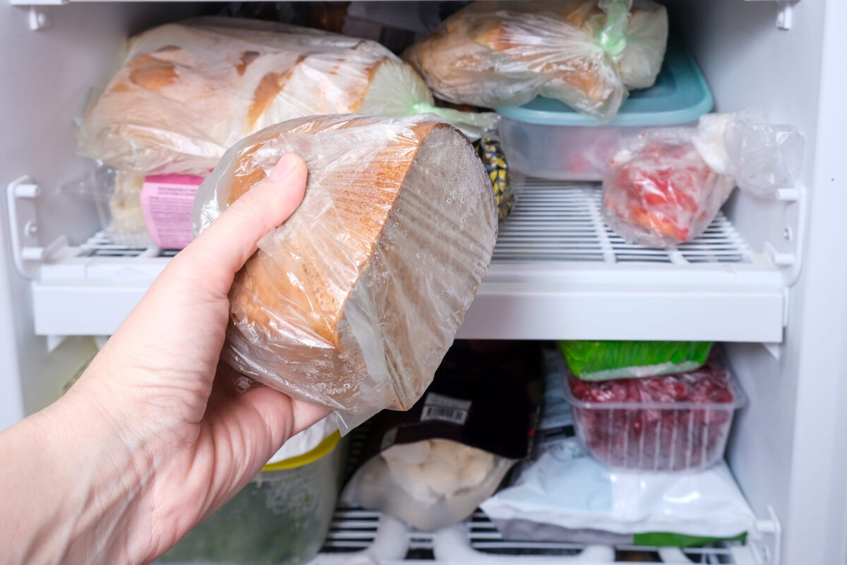 8 Storage Mistakes That Are Ruining Your Food 2 A hand putting a package of brown bread in reserve on a shelf of a home freezer, long life food storage concept