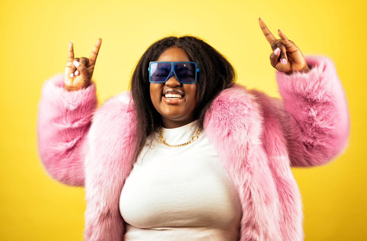 Evaluating the Role of Beauty Standards in Eating Disorders 2 Image of a beautiful woman posing in a furry coat on a yellow background