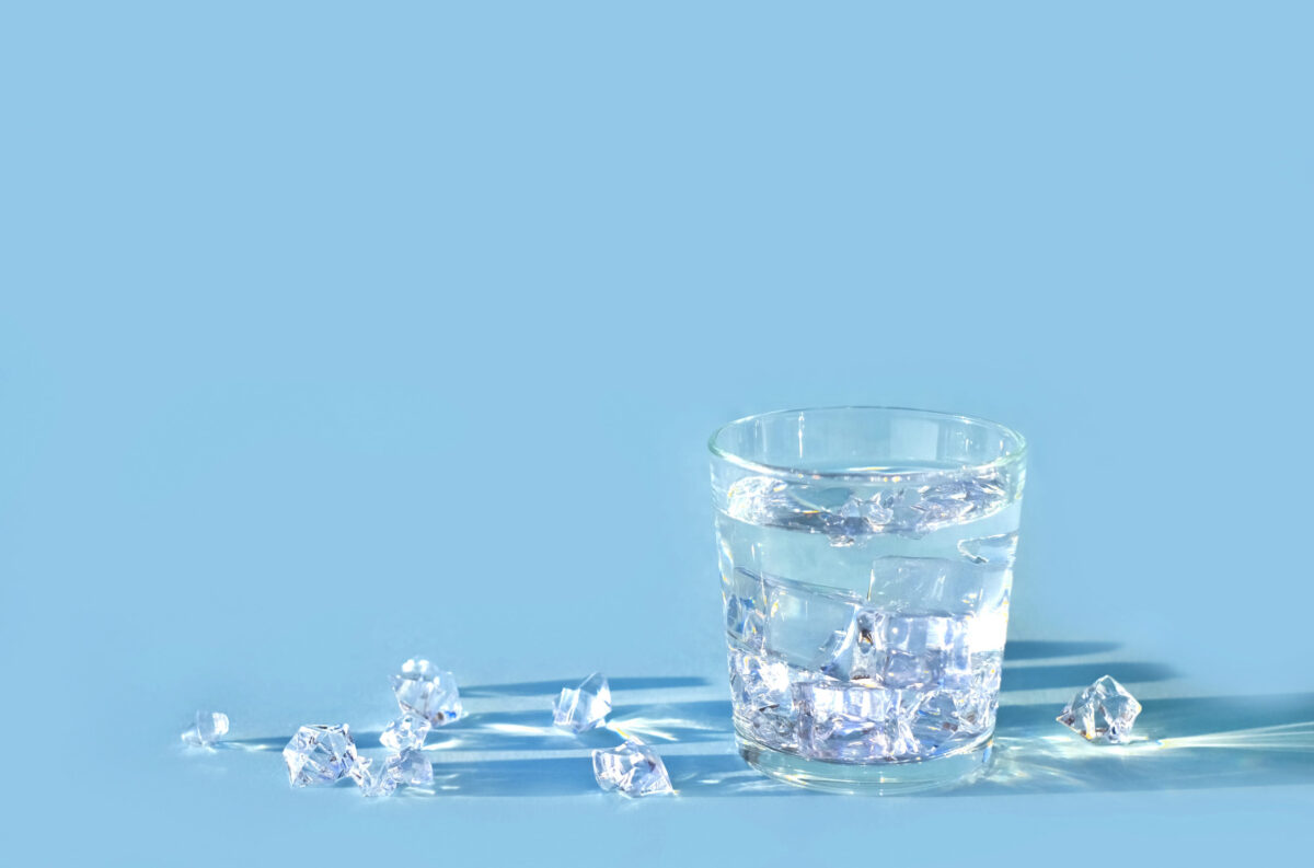 8 Ways to Avoid Food Poisoning 4 Water in glass with ice cubes on blue background, shadows, copy space.