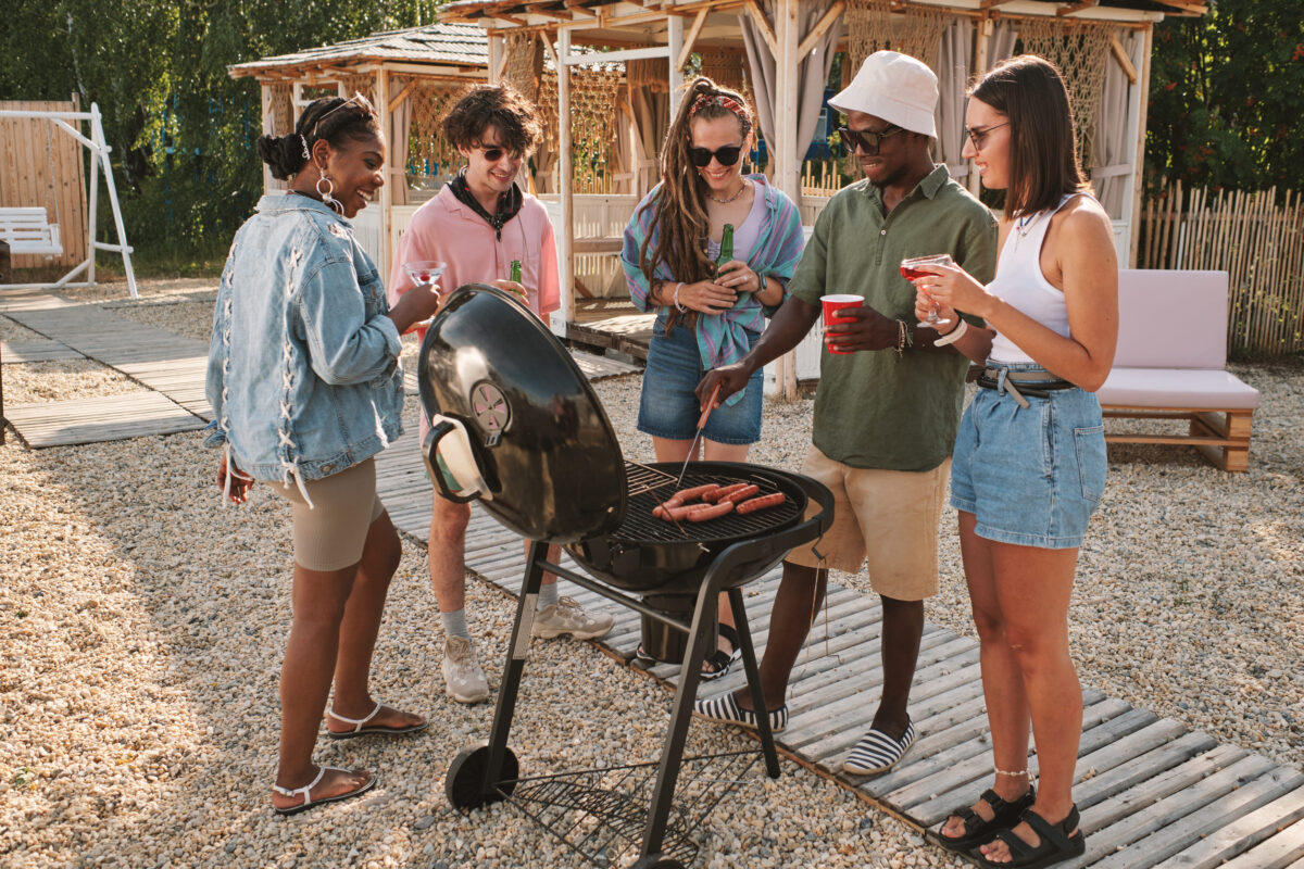10 Painful Signs Someone Secretly Dislikes You More Than They Admit 5 Diverse group of friends frying hot dogs on grill at beach party, drinking and talking
