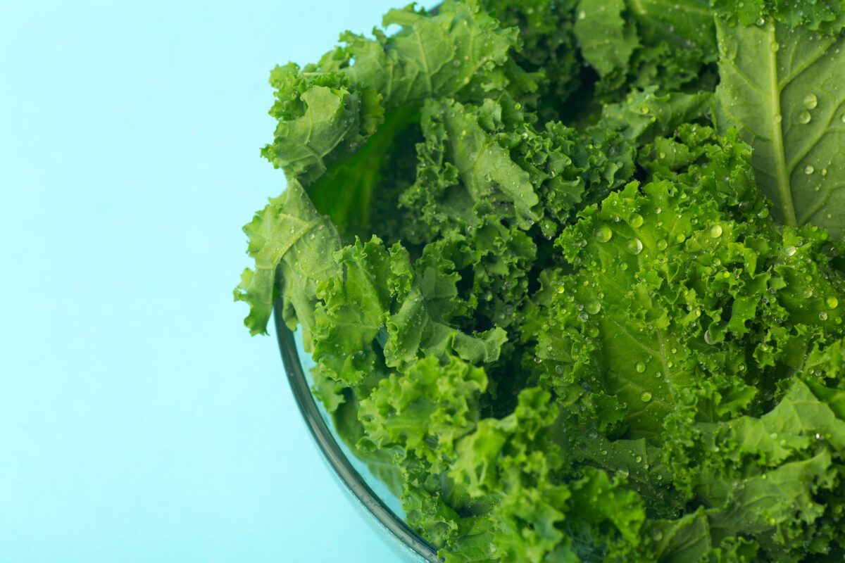 8 Things Nobody Tells You About Superfoods 3 Green salad in a glass bowl on a blue background. Healthy and proper food, lifestyle concept. Vegetarian and vitamins.