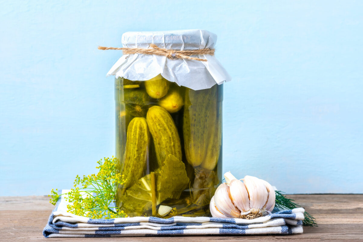 8 Surprising Old Foods That Have Stood the Test of Time 4 Homemade pickled cherry tomatoes, cucumbers, champignons, garlic, eggplant, red peppers in jars on wooden shelf Homemade canned and fermented foods concept Seasonal product