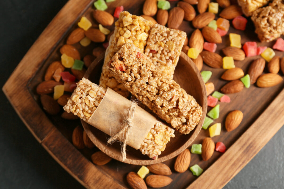 10 Shocking Things You Won’t Believe Are Really in Your Favorite Snacks 1 Plate with healthy cereal bars, candied fruits and nuts on dark background