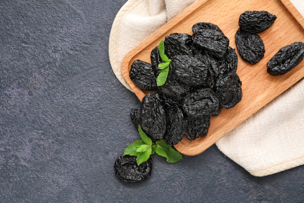 7 Banned Ingredients That Prove America’s Kitchen Had a Dark Past 3 Board with tasty prunes on dark background