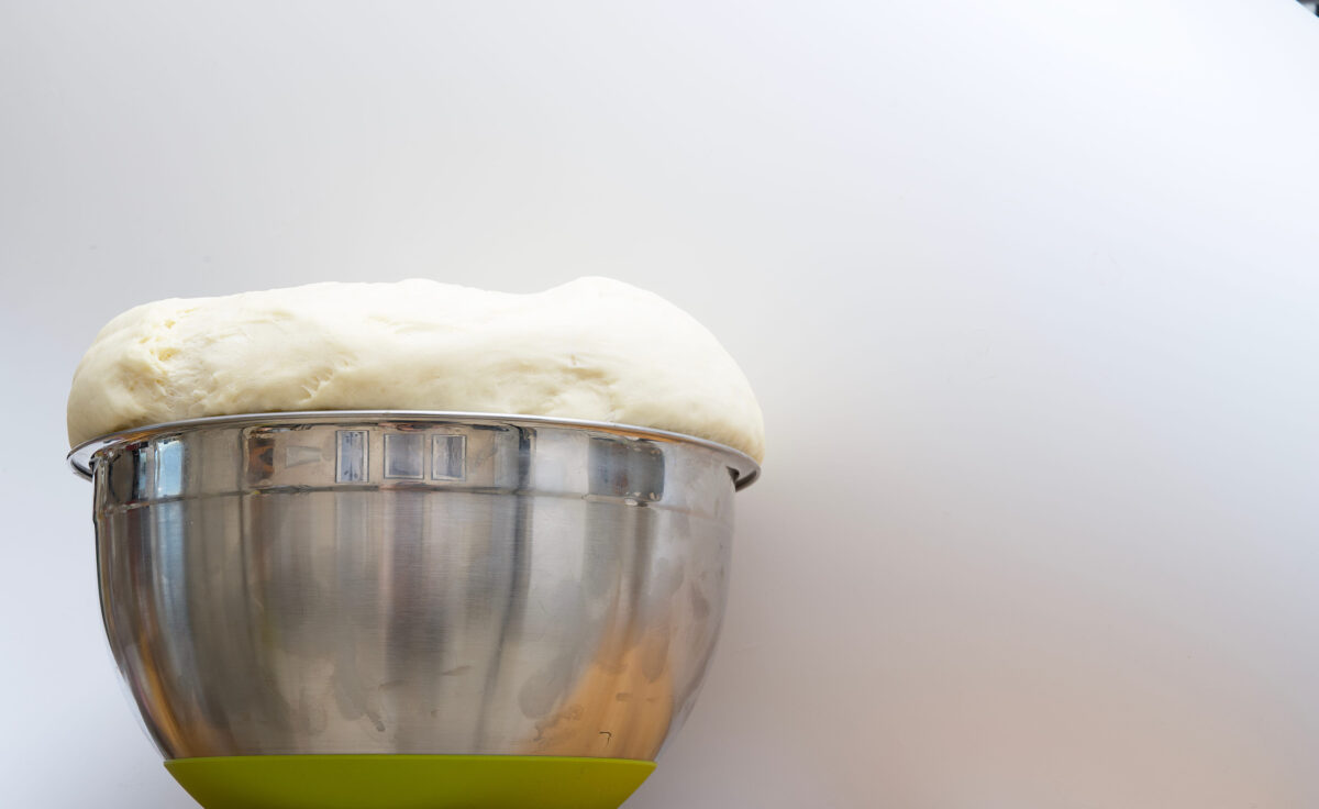 8 Freezer Foods You Should Toss Immediately for Your Health and Safety 4 Rising yeast dough in a large metal pot is on the wooden table at a cozy farm home kitchen, preparing for making hot dogs and pies. Mastery of cooking at home.