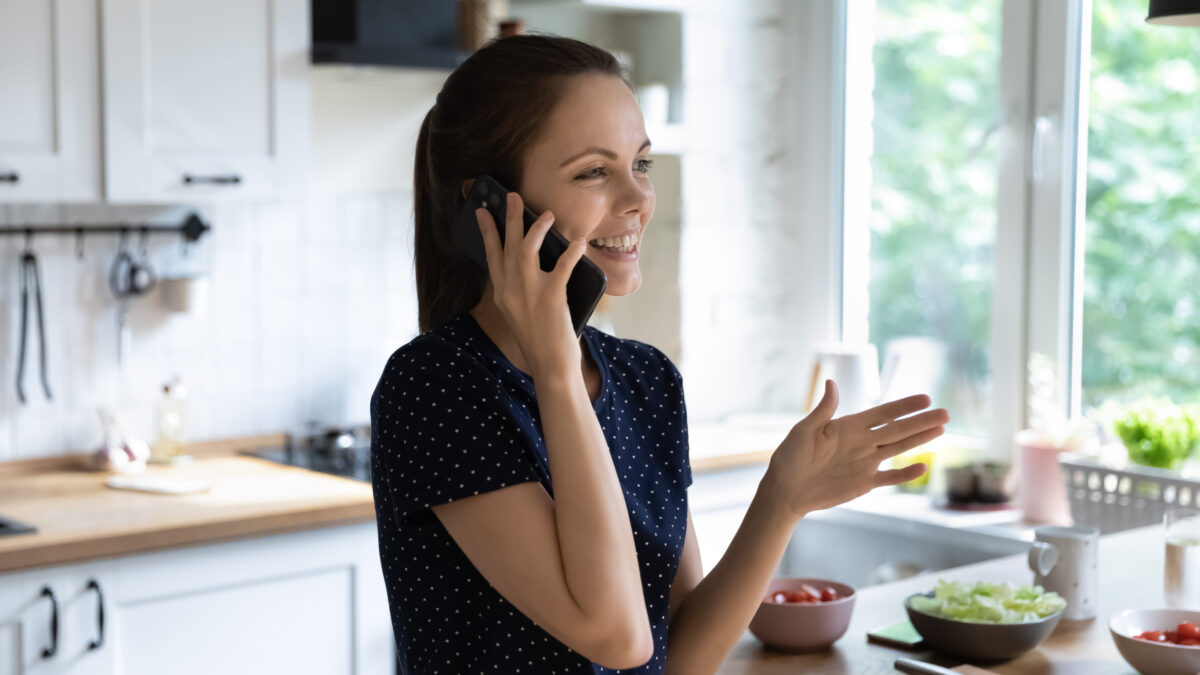12 Breakfast Mistakes That Make Your Entire Day Worse 1 Happy joyful chef girl making telephone call in kitchen, cooking salad from fresh vegetables for dinner, talking on mobile phone at table with healthy food, smiling, laughing. Domestic work concept