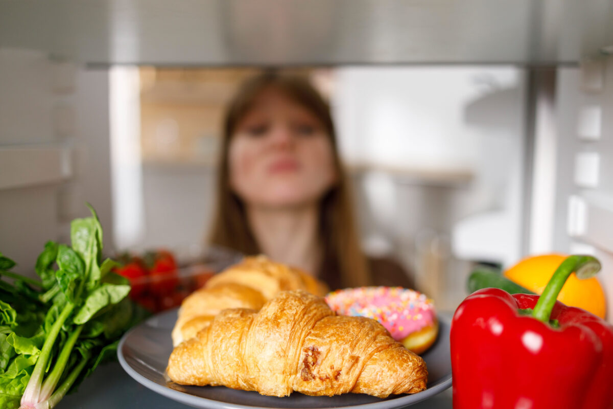 8 Storage Mistakes That Are Ruining Your Food 4 Selective focus of woman looking into fridge at the kitchen. Sweets and vegetables on the refrigerator shelf