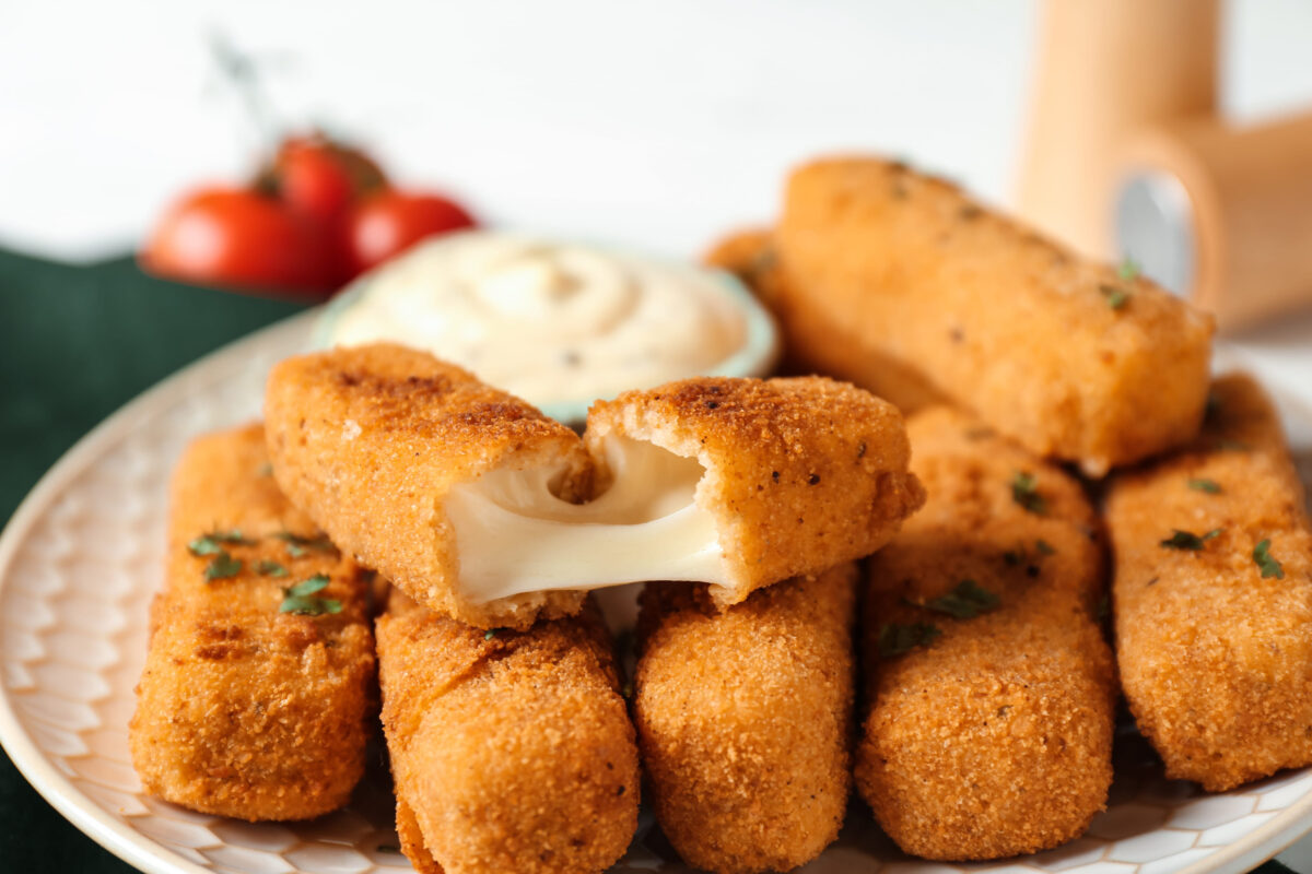 9 Foods You Should Never Order at a Chain Restaurant 2 Plate of tasty crispy cheese sticks, closeup