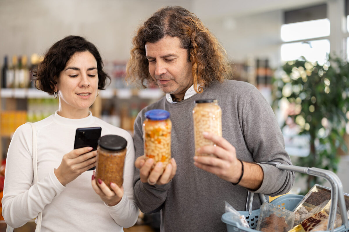 8 Outdated Boomer Eating Habits That Are Hurting Your Health and Need to End 1 Checking expiration date of beans - wife and husband shoppers scans QR code on label of jar beans and lentils using smartphone