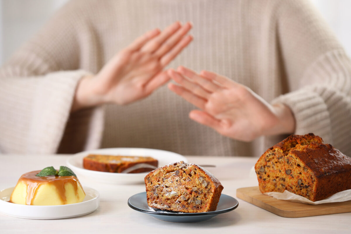 The Rude Behaviors That Can Completely Ruin a Potluck 4 Woman refusing to eat products at table indoors, selective focus. Food allergy concept