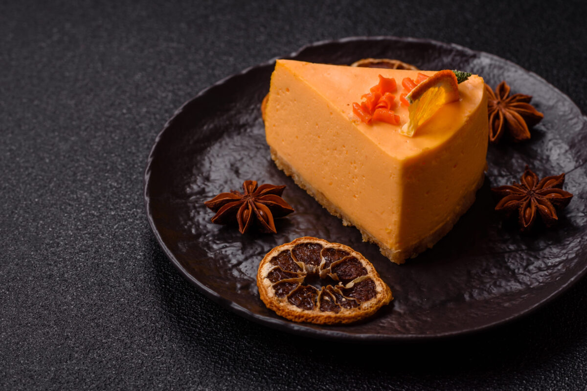 A slice of yellow cheesecake cake flavored with lemon and passion fruit. Cheesecake, home baking, birthday sweets
