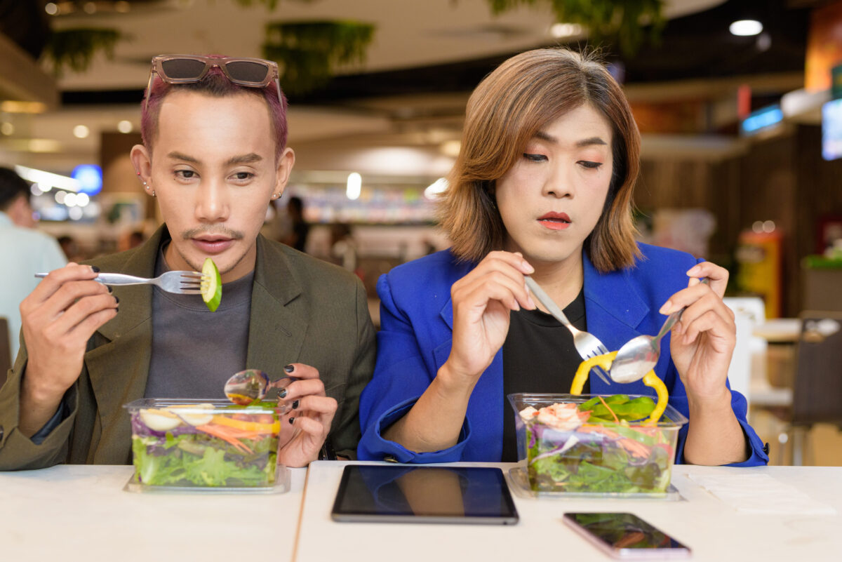 9 Common Habits that Make Men Appear Cheap 4 Gender diverse Asian coworkers eating salad and working digitally