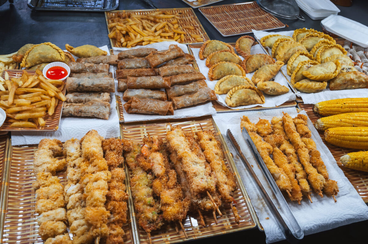 Top Foods to Avoid When Managing High Cholesterol for a Healthier Heart 2 Traditional Vietnamese food and pastries on counter at Asian night market on the street in Vietnam in Asia