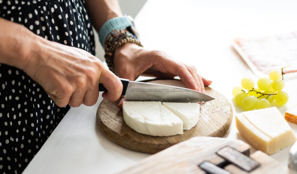 Why These 7 Protein-Packed Foods Are Actually Holding Back Your Fitness Goals 4 Girl Cutting Cheese On A Board For A Cheese Board And Placing Brie Cheese On A Plate