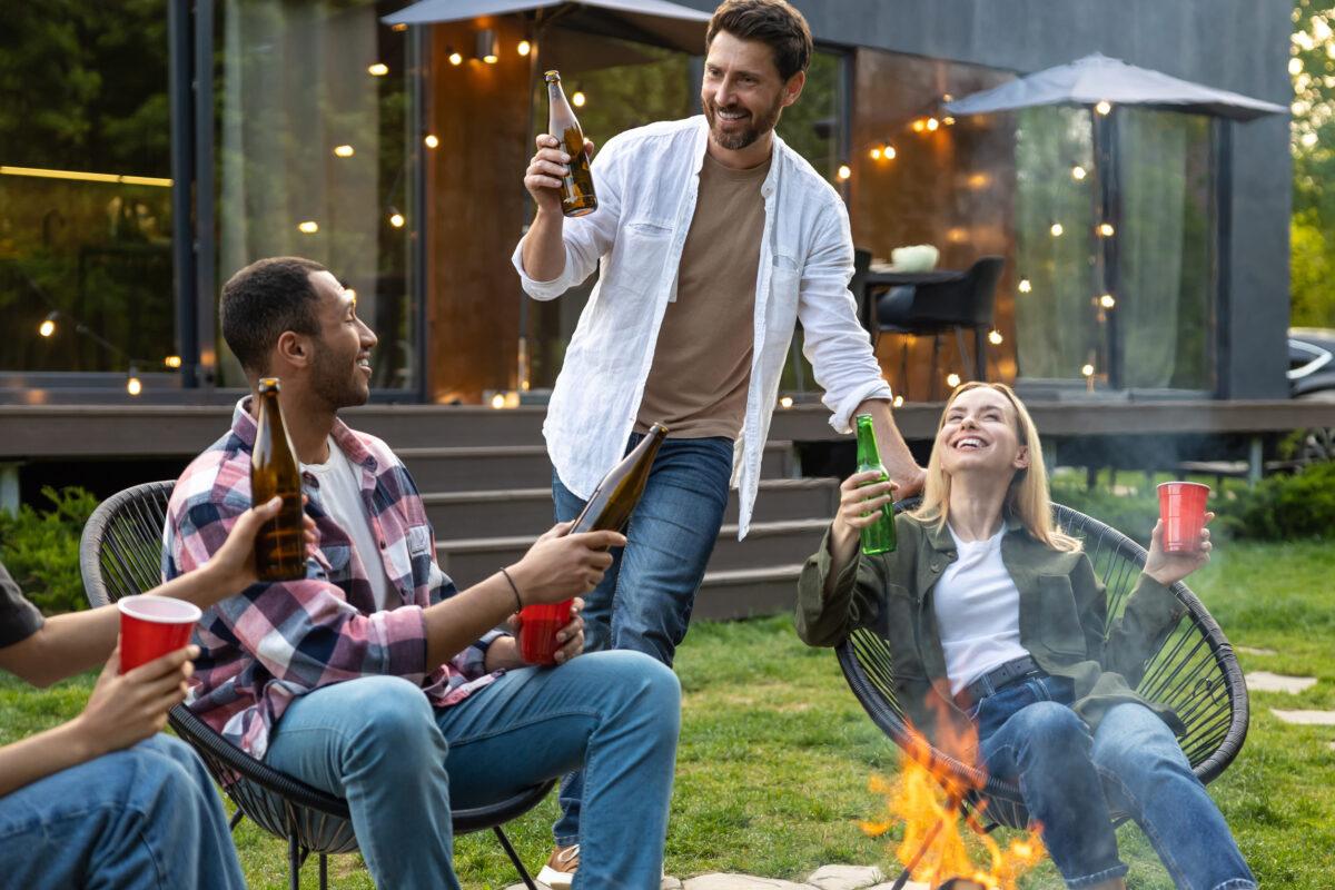8 Etiquette Mistakes That Will Make You the Worst Guest at a Barbecue 4 Young happy friends having picnic having fun and celebrating while grilling at barbecue party