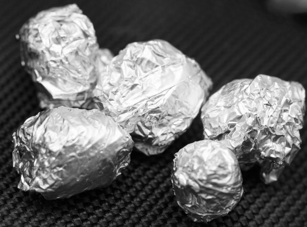 Foods You Should Never Cook in Aluminum Foil 4 crumpled foil on a black background