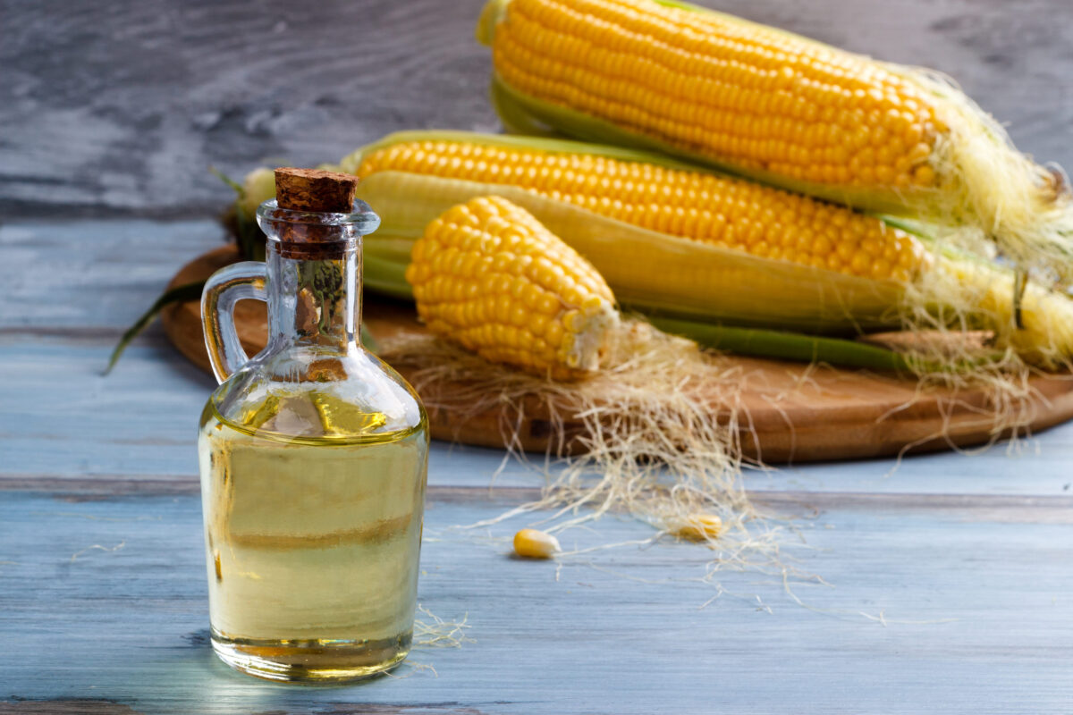 8 Common Cooking Oils You Should Never Use 2 Fresh corn with bottle of oil on wooden background