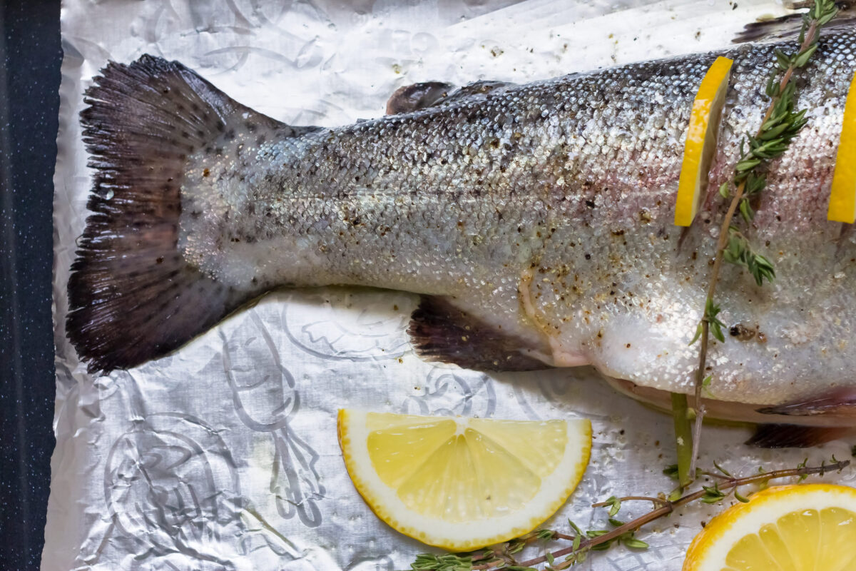 Avoid These 10 Foods on a First Date, They Could Destroy Your Chances 1 River fish trout on a baking sheet stuffed with lemon wedges and a sprig of green thyme. Shallow depth of field