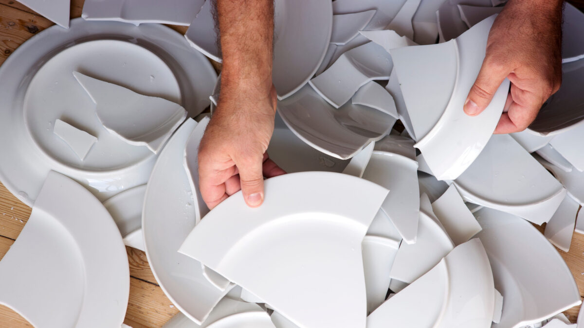 8 Common Potluck Problems and How to Solve Them Like a Pro 4 hands picking up broken white plates from wooden floor
