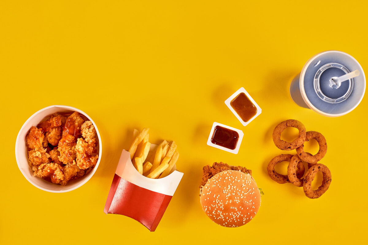 10 Fast Food Fails That Will Make You Think Twice Before Ordering 4 Fast food dish top view. French fries, hamburger, mayonnaise and ketchup sauces on yellow background.