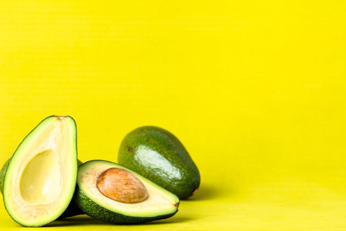 The 10 Worst Foods for the Planet and How Your Diet Is Destroying the Earth 3 Avocado halves and group of Avocados on yellow pastel background, food concept