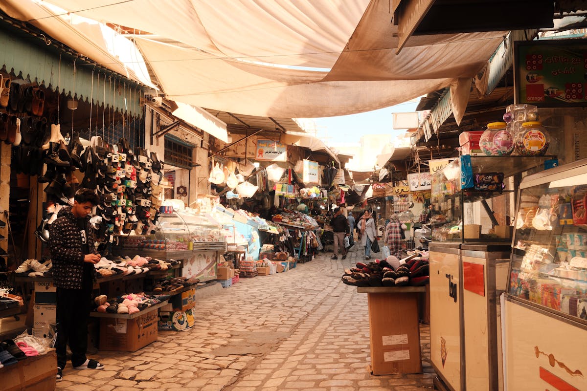 10 Political Scandals That Shook Nations and Triggered Mass Uprisings 5 A bustling market in Sfax, Tunisia, filled with local vendors and shoppers enjoying the day.