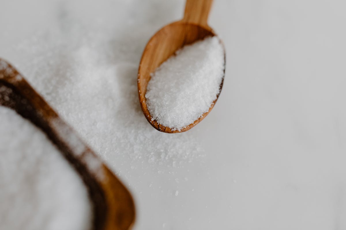 10 Weird Things Governments Actually Taxed 4 A close-up image of granular salt in a wooden spoon, perfect for culinary themes.