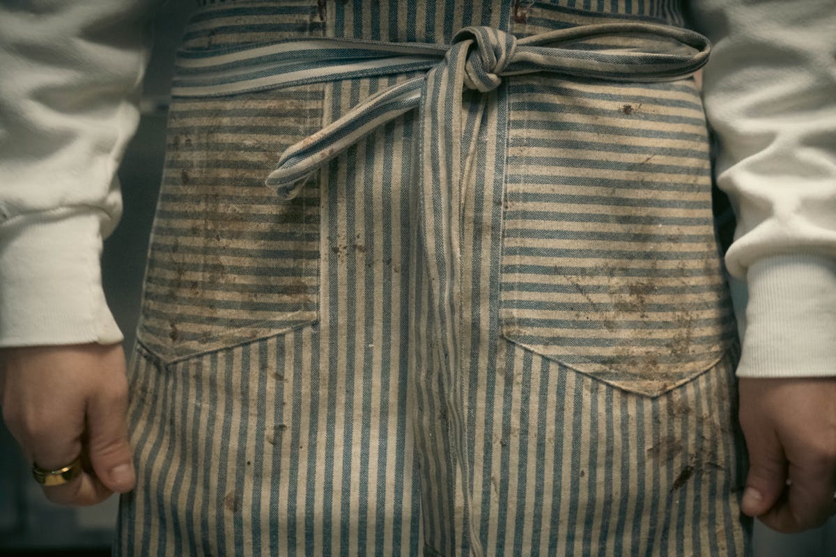 11 Laundry Mistakes to Avoid 3 A close-up of a person wearing a striped apron, highlighting texture and detail.