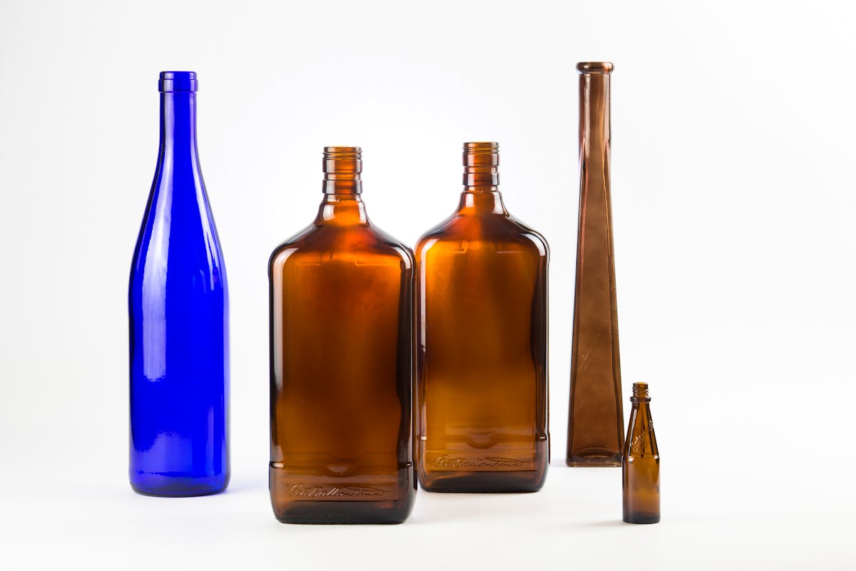 10 Strangest Objects Doctors Actually Removed From Human Bodies 4 A collection of vintage glass bottles in various shapes and colors displayed against a white background.