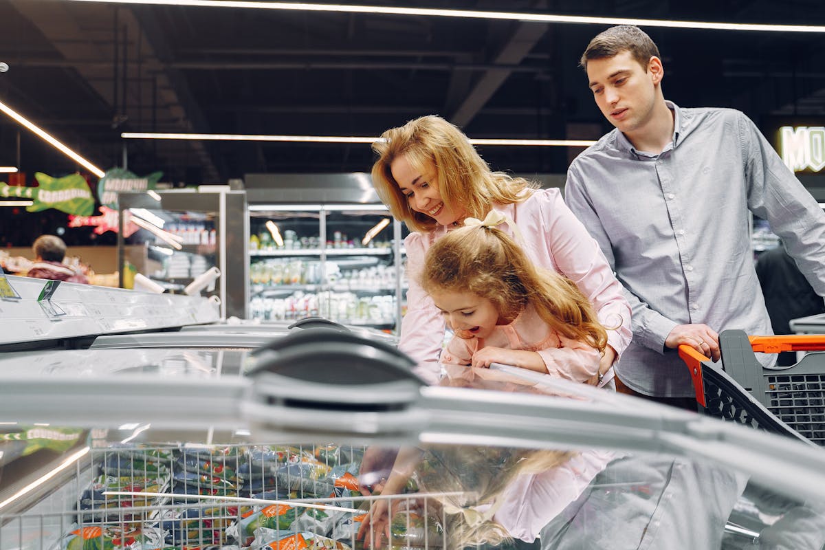 10 Grocery Tips To Avoid Ruining Your Budget 3 A family enjoying time together while shopping in a supermarket aisle.