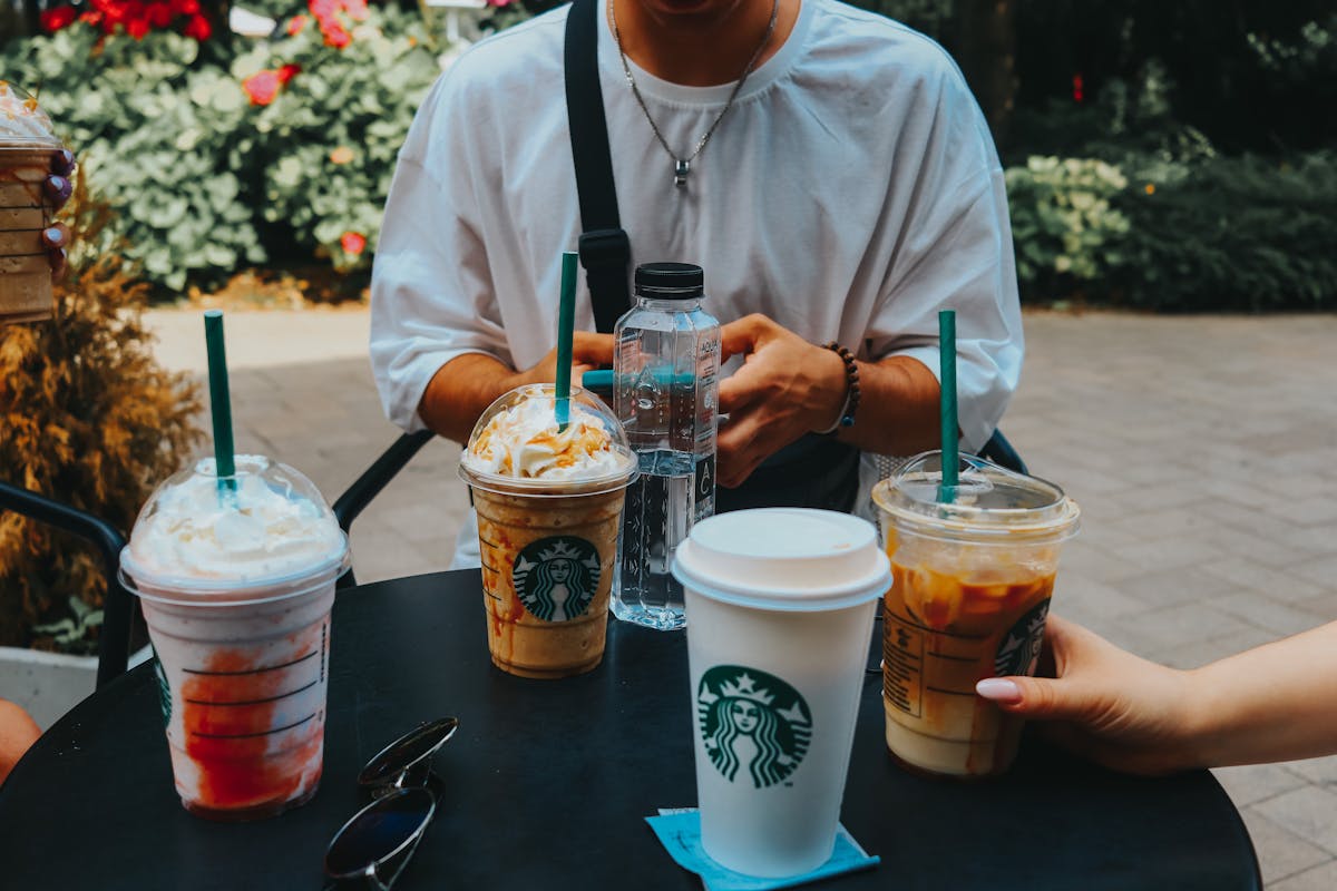 7 Unusual Fast-Food Scandals and Lawsuits That Shook the Industry 3 A group enjoying Starbucks coffee outdoors, capturing casual social moments.