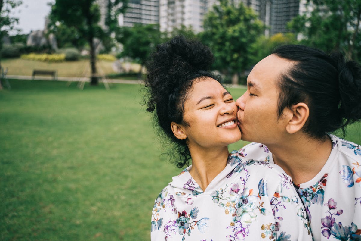 10 Odd Habits That Make Relationships Stronger 1 A happy couple sharing a loving moment in a scenic park landscape.