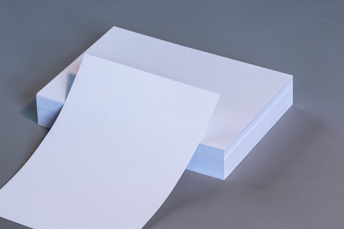 10 Things to Never Pay Full Price For 2 A high-quality image showing blank white paper sheets stacked on a neutral gray surface.