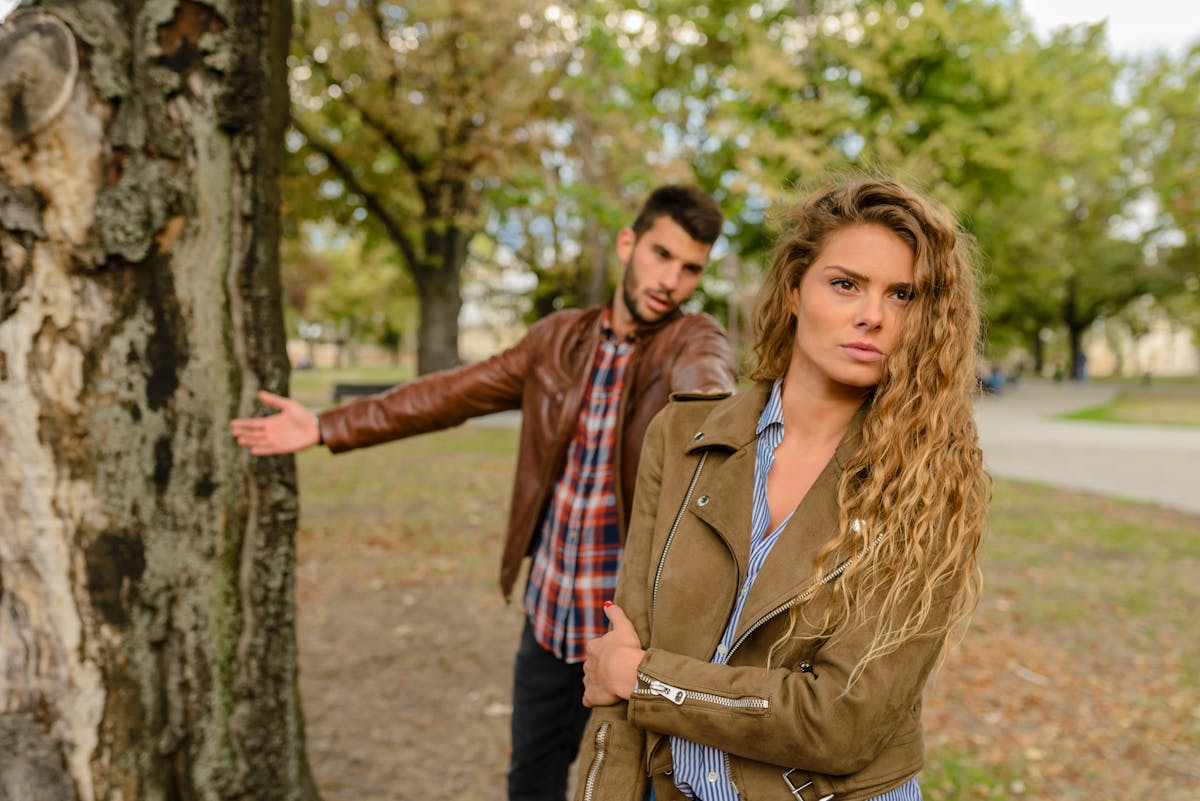 10 Things You Should Never Say to Your Partner 3 A man and woman in a heated argument outdoors, expressing emotions.