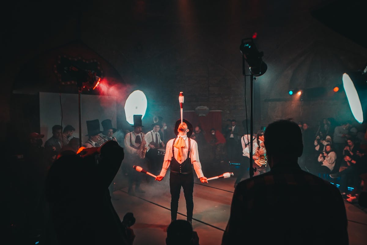 10 Towns in the U.S. That Feel Too Weird to Be Real 4 A mesmerizing circus juggler performs under dramatic lighting during a lively festival.