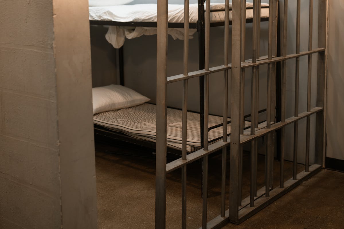 6 Weird Things on Cruise Ships Most Passengers Never Expect to Find 1 A prison cell featuring a metal bunk bed and striped sheets.