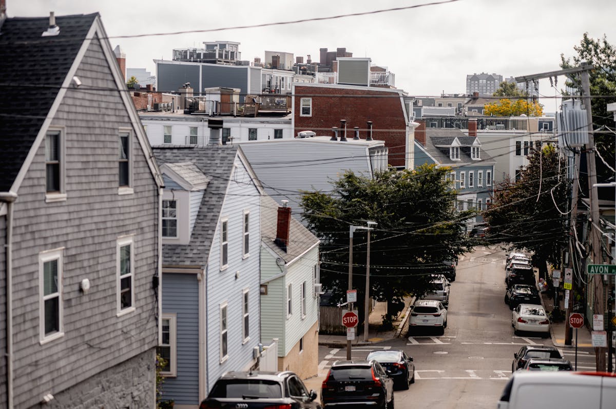 11 Things You Shouldn’t Overlook Before Purchasing a House 2 A scenic view of a residential neighborhood street with classic architecture and parked cars.