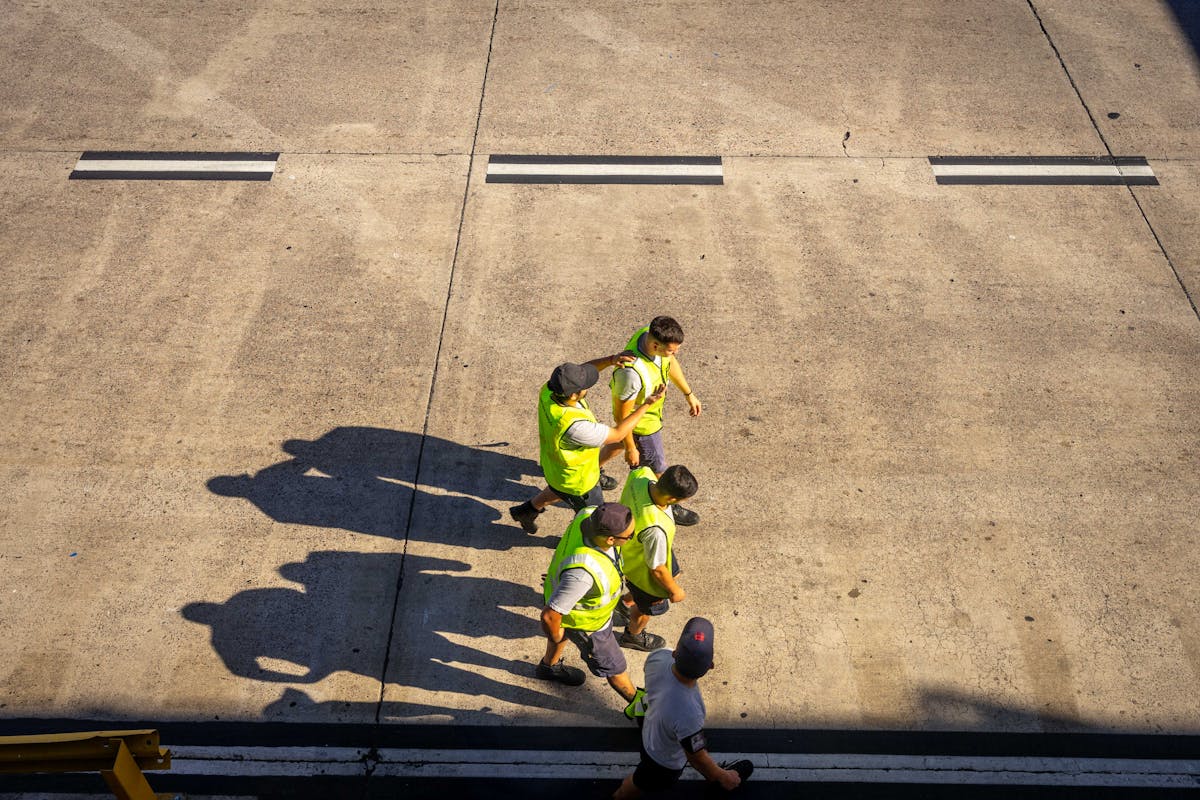 10 Ways People Got Paid to Do Nothing 4 Aerial view of airport workers walking on the tarmac in Buenos Aires on a sunny day.