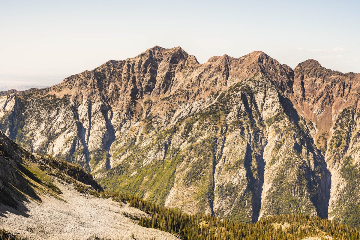 The 10 Most Dangerous Hikes in the World 3 Aerial view of rugged Rocky Mountains showcasing dramatic peaks under clear skies.