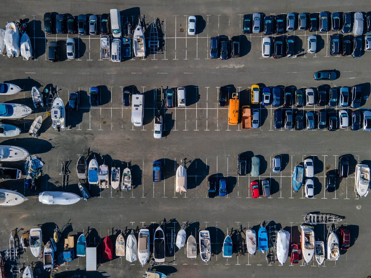 8 Unusual Reasons People Got Banned from Places for Life 4 Aerial view showcasing parked boats and cars in a sunny lot. Ideal for transport themes.