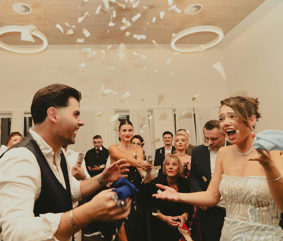 8 Painful Ways People Got Dumped That No One Deserves 3 Bride and groom celebrating at a lively indoor wedding reception with friends and family.